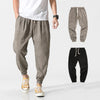 Man wearing light brown linen blend drawstring pants with tapered legs