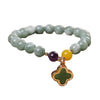 Green beaded bracelet with a gold-tone four leaf clover charm