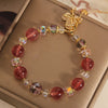 Natural strawberry quartz bracelet with gold-tone butterfly charm on a box