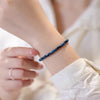 Close up of a blue tiger eye stone bracelet on a woman's wrist