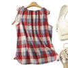 Red plaid sleeveless tank top hanging on a wooden hanger