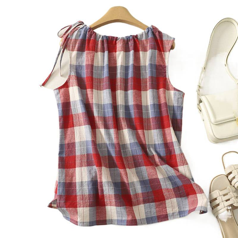 Red plaid sleeveless tank top hanging on a wooden hanger