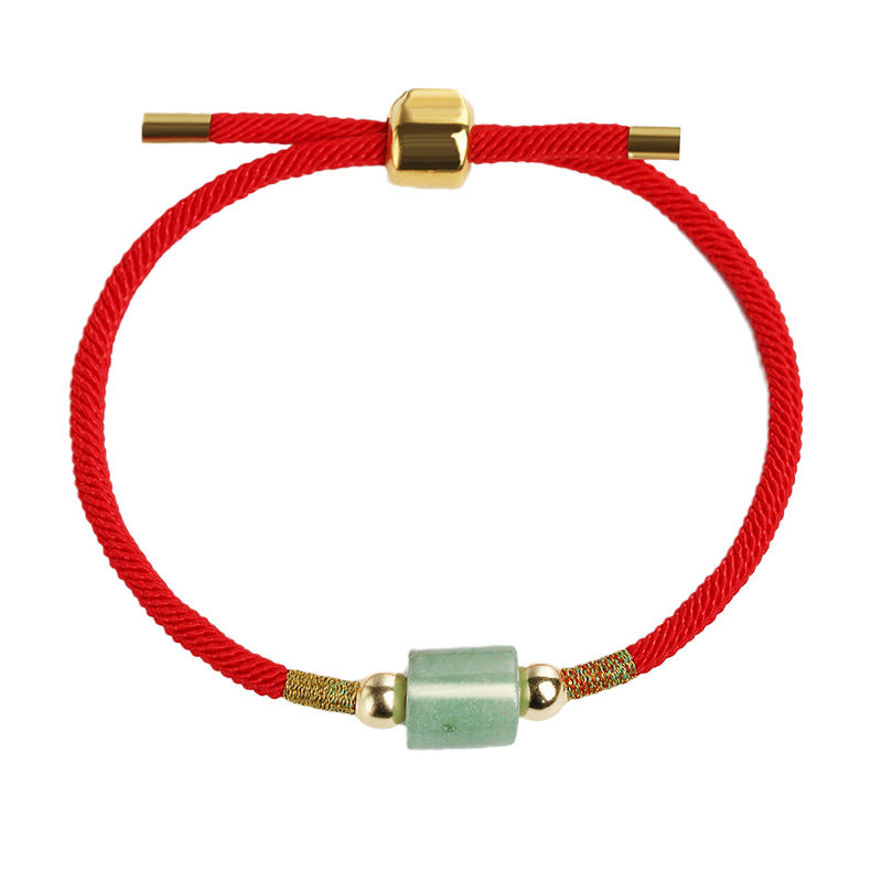 Close up of a green aventurine stone bracelet on a red cord worn on a wrist
