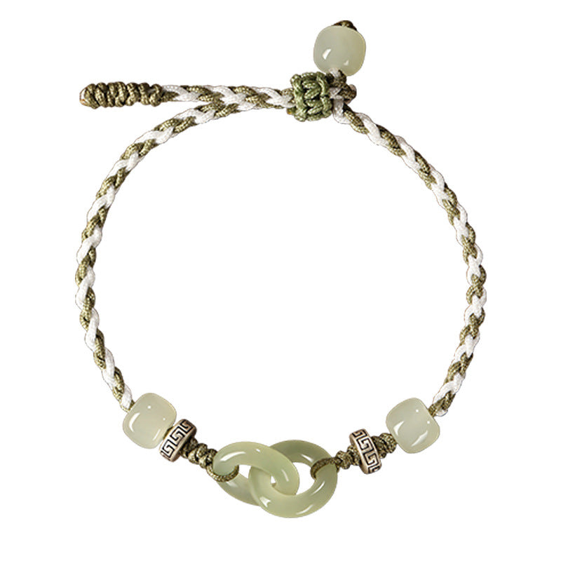Close up of a green jade bracelet with interlocking rings on a braided cord