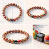 Close-up view of a multi-colored natural stone bead bracelet with a central silver-tone cube bead.