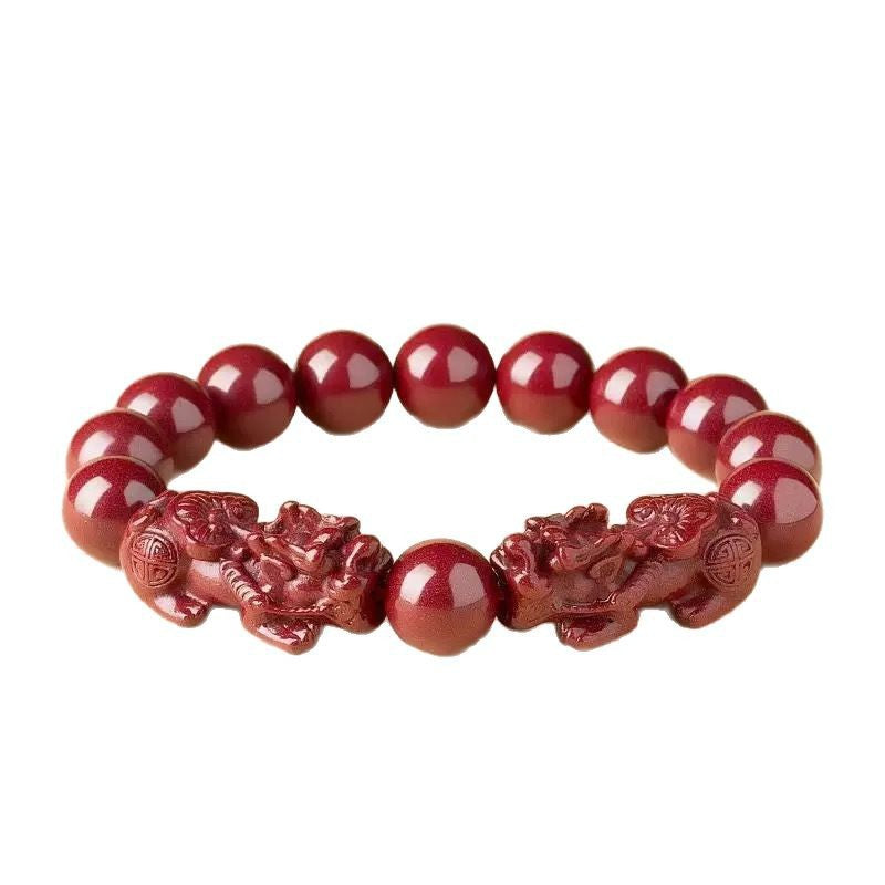Close up of a red cinnabar bracelet with two carved mythical creatures