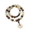 Double wrap wooden bracelet with white bodhi seeds and a round pendant charm on a wrist