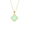Close up of green four leaf clover pendant on gold chain