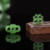 Green hand carved jade pendant bead on a wooden block