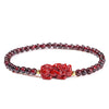 Red garnet beaded bracelet with a carved Pixiu charm and a pink square bead on a white background