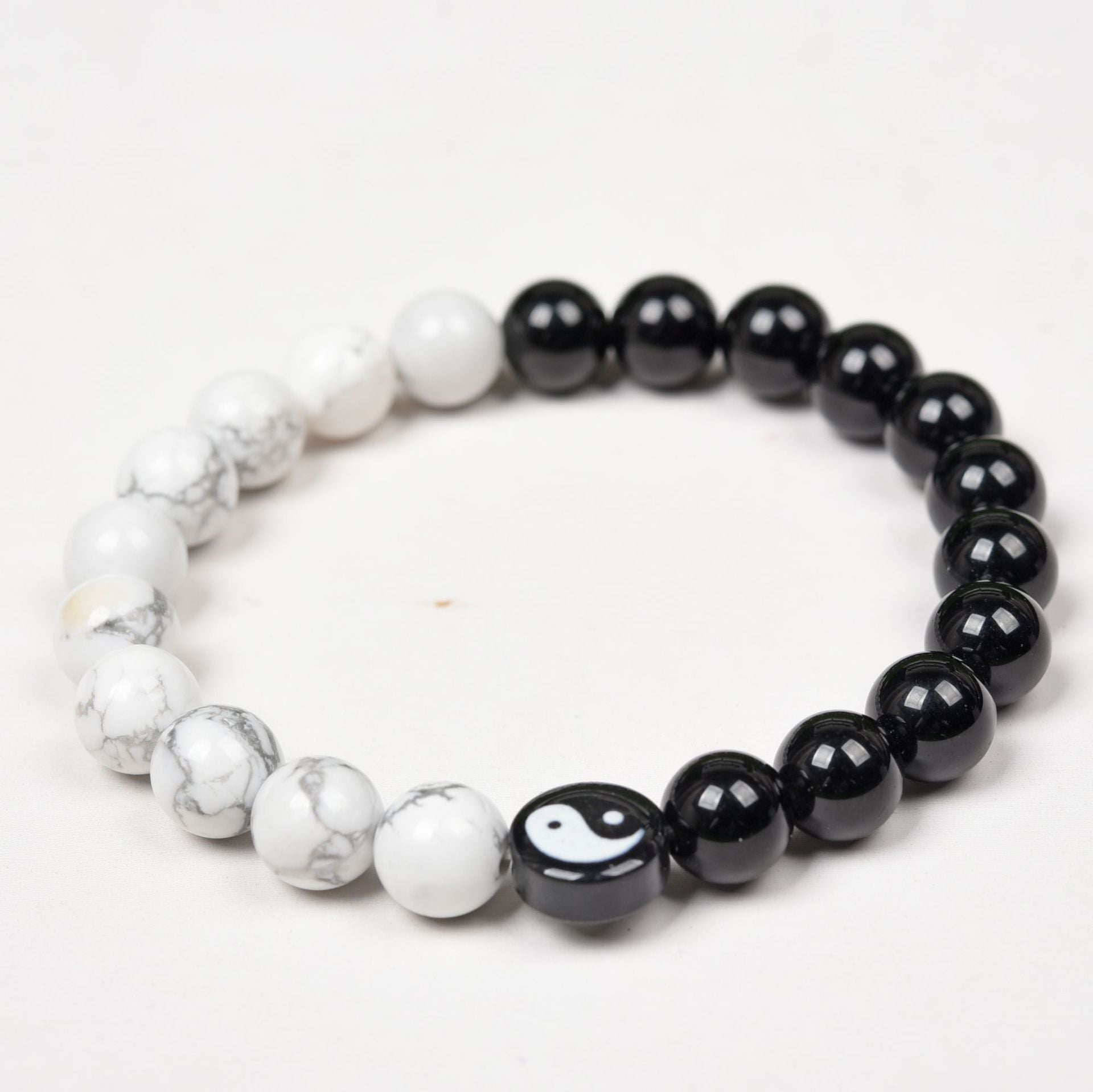Close up view of black obsidian and white turquoise yin yang bracelet