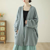Woman wearing a light green loose cotton linen zen jacket with pockets