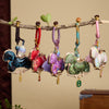 Five colorful fabric horse keychains hanging from a branch