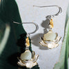 Pair of silver tone lotus flower earrings with a white jade center
