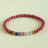 Red cinnabar beaded bracelet with five colorful natural gemstones and gold-tone spacers