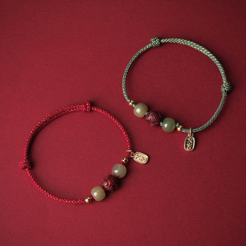 Two braided bracelets with jade beads and a lotus charm on a red background