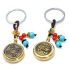 Gold-tone metal keychain with spinning coin charm and red and blue beads