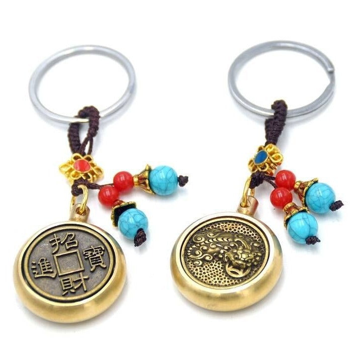 Gold-tone metal keychain with spinning coin charm and red and blue beads