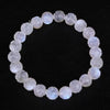 Close-up of a white moonstone bracelet with carved lotus flower beads on a black background