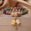Close up of a colorful beaded bracelet with yellow flower charms on a box