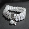 White cat eye triple wrap bracelet with silver tone lucky cat charm