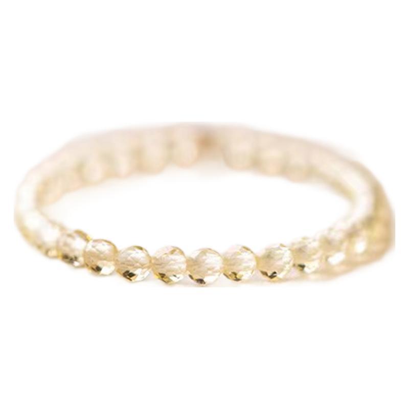 Close up of a hand wearing a delicate gold-tone ring with small yellow citrine crystals