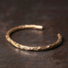Close up of a textured hammered copper open cuff bracelet