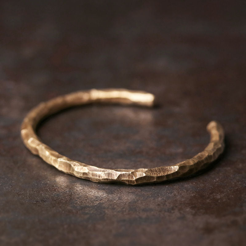 Close up of a textured hammered copper open cuff bracelet