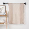 Beige striped cotton blend scarf hanging on a black wall rod