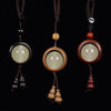 Three wooden keychains with glowing beads and gourd charms hanging on a black background