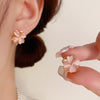 Close up of pink cat's eye flower stud earring on ear