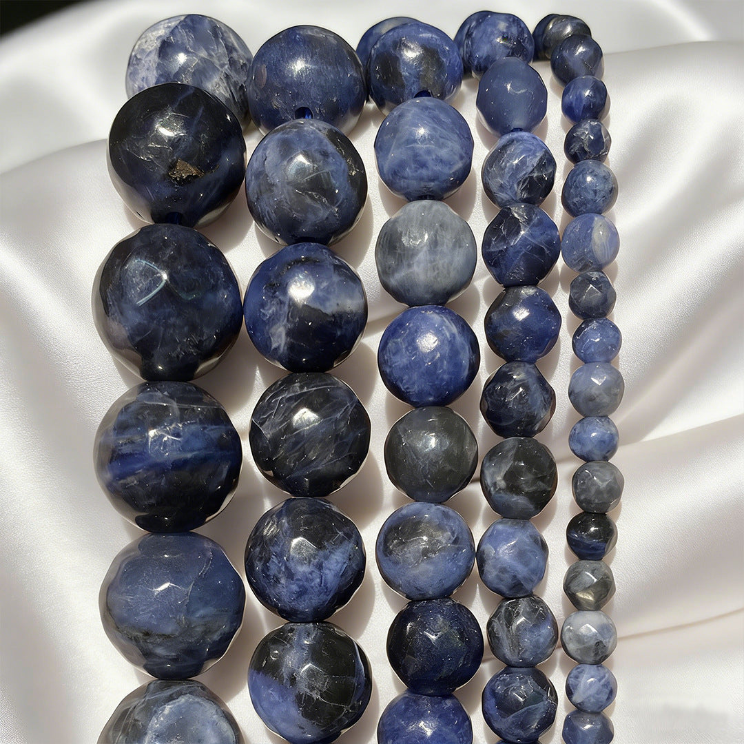 Strands of polished blue natural stone beads on white fabric