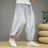 Man wearing light gray loose harem pants with white shoes