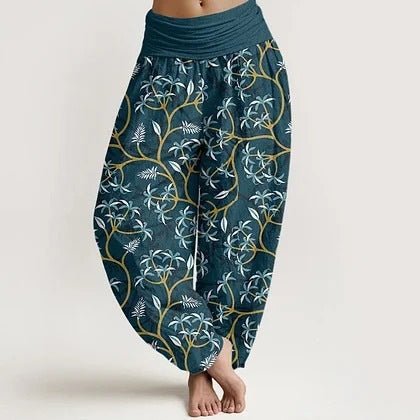 Side view of women's teal harem pants with white and gold floral vine pattern