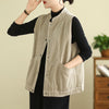 A woman wearing a beige corduroy vest with pockets over a black shirt