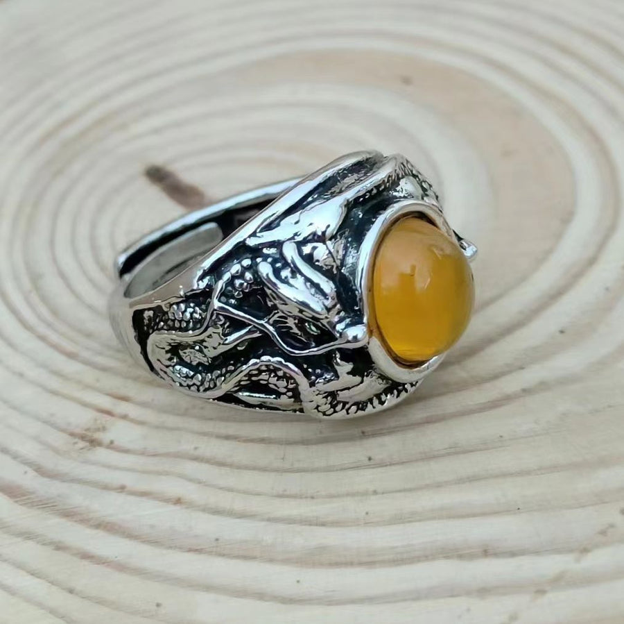 Silver-tone open ring with a dragon design and a round orange stone