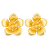 Pair of small gold-tone flower stud earrings made of sterling silver on a wooden surface