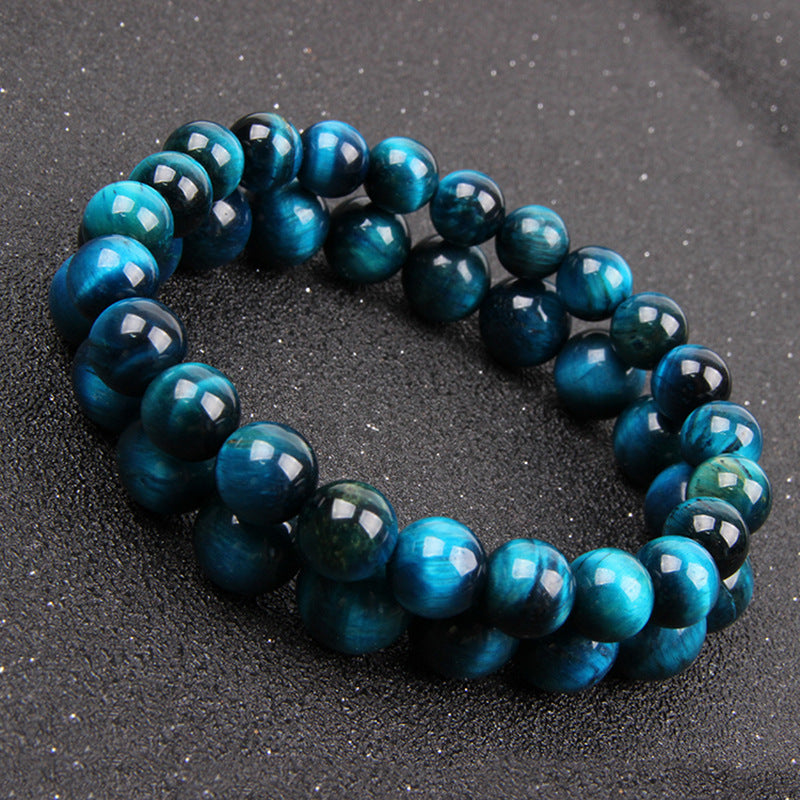 Polished blue tiger eye beaded bracelet on a dark surface
