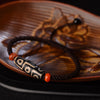 Close-up of a Tibetan nine-eye Dzi bead bracelet on a wooden plate