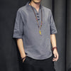 Man wearing a grey linen short sleeve shirt with a V-neck and buttons