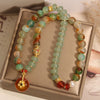 Close up of double layer green agate bracelet with orange pendant