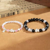 Two beaded bracelets with Pixiu charms resting on a wooden surface