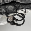 Close up of silver sheen obsidian lucky cat bracelet on black cord