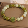 Green jade bead bracelet with gold flower spacers on a box