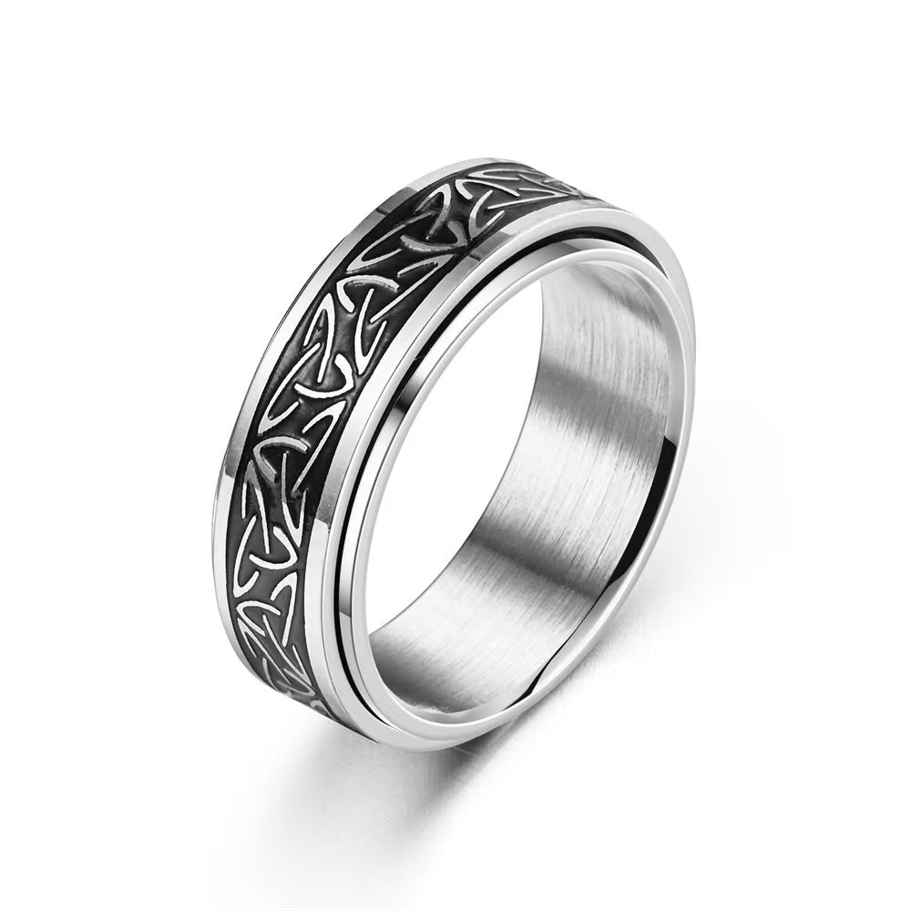 Close up view of a silver titanium steel ring with a black rotating triquetra knot band