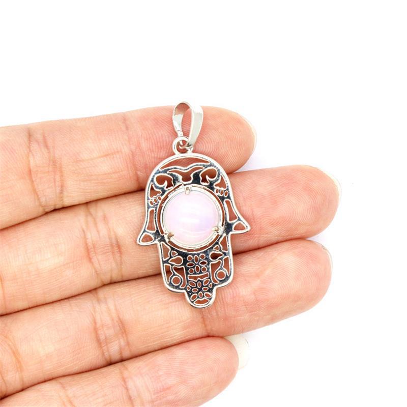 Silver tone Hamsa hand pendant with a central pink stone