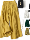Flat lay of mustard yellow wide leg cotton linen pants with white sneakers