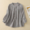Flat lay of a grey cotton linen button up shirt with three quarter sleeves