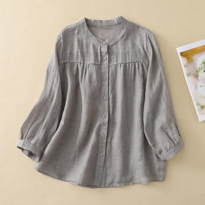 Flat lay of a grey cotton linen button up shirt with three quarter sleeves