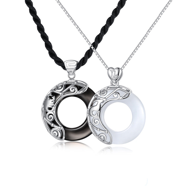 Pair of silver zodiac constellation pendants, one black obsidian and one white stone